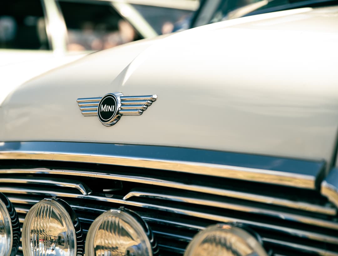 Winged Mini badge above the chrome grille and spotlights of a classic Mini