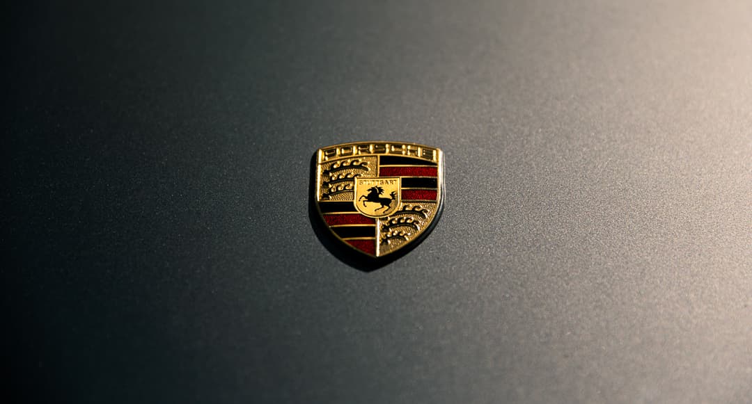 Porsche crest badge on the bonnet of a dark grey sports car