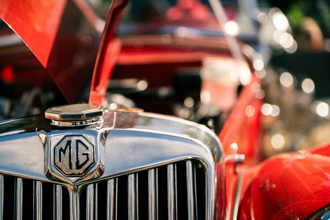 Chrome radiator cap and MG badge on a red pre-war MG with its bonnet open