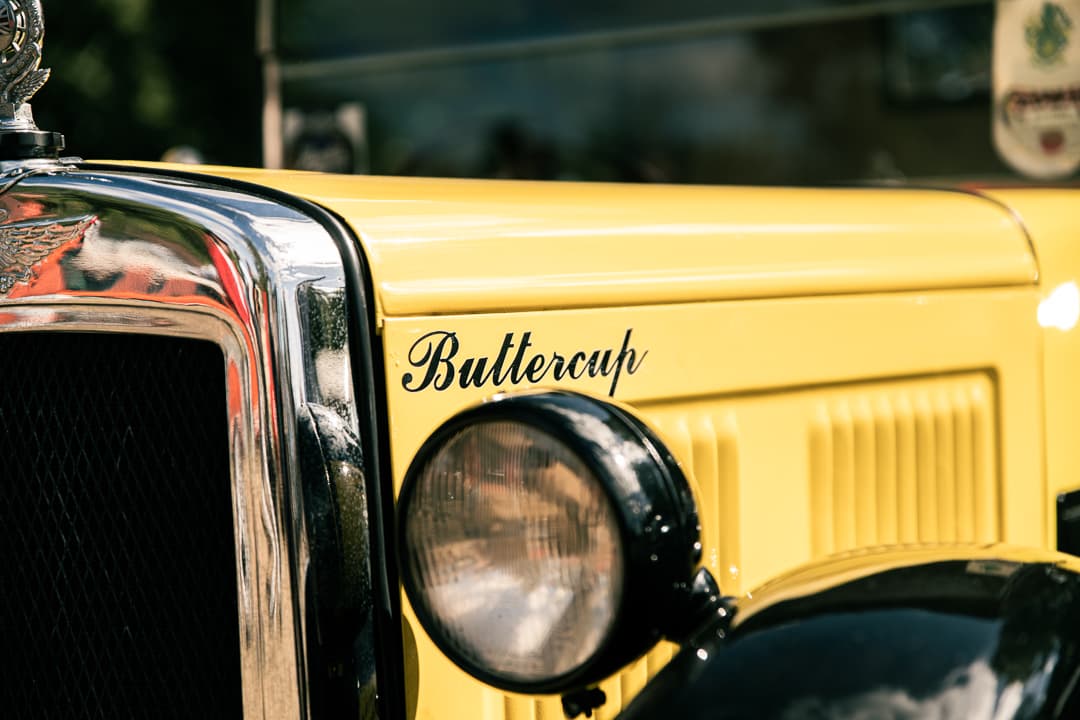 Buttercup lettering and round headlamp on a yellow vintage van
