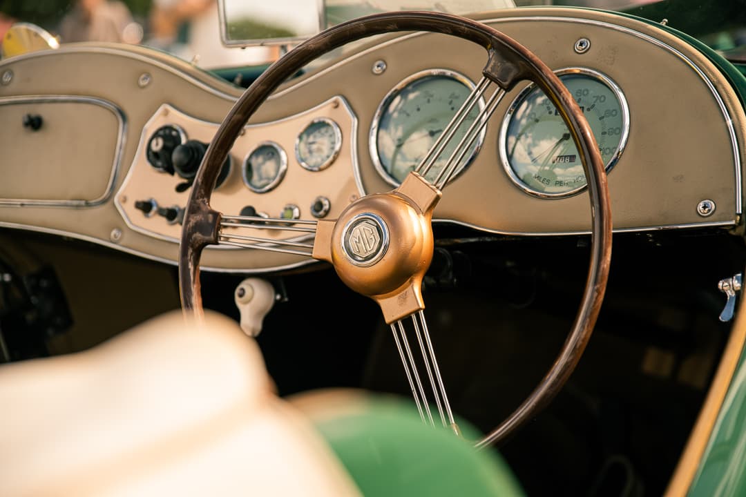 Wood-rimmed steering wheel and dashboard dials in a green pre-war MG