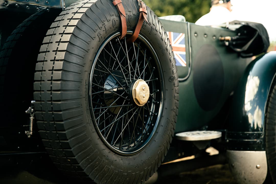 Spare wire wheel and Union Jack on the back of a dark green vintage racer