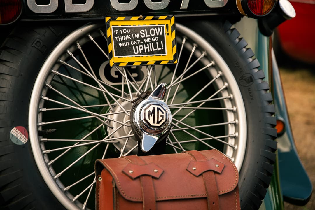 Humorous sign and MG badge on the spare wheel at the back of a vintage MG