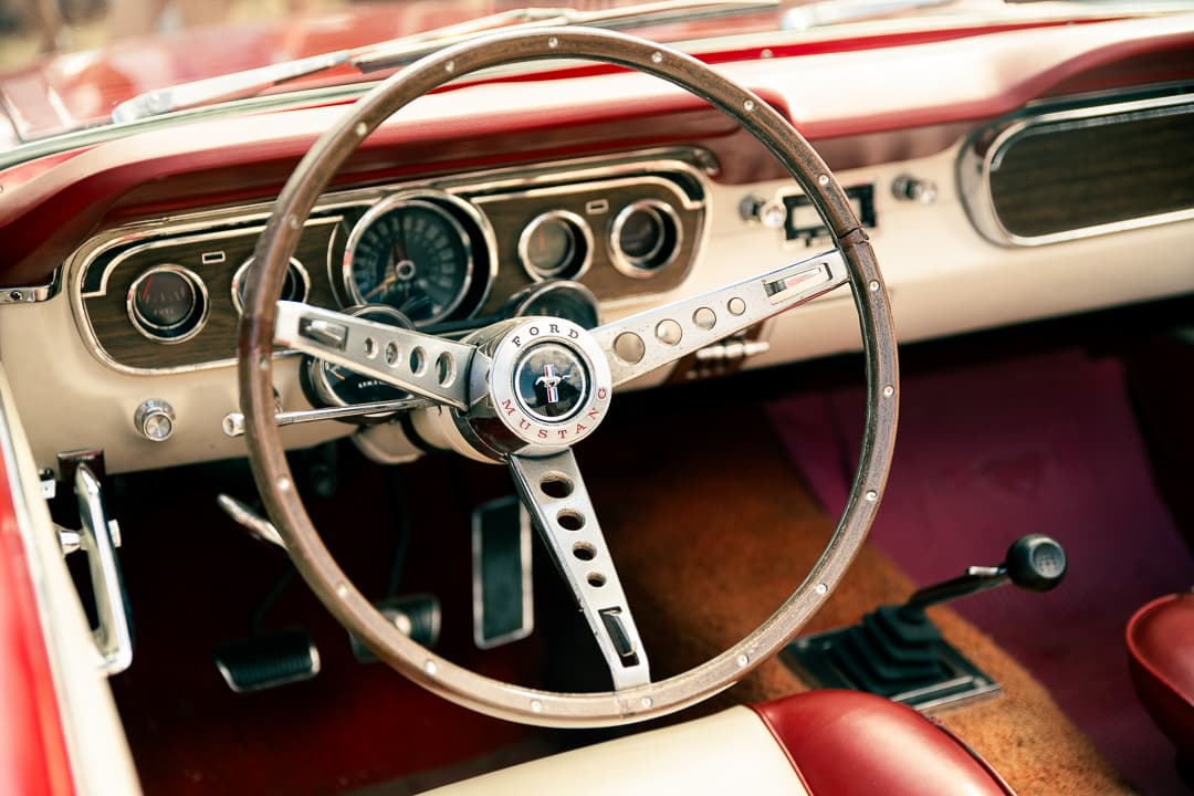 Chrome steering wheel with pony badge inside a 1966 Ford Mustang