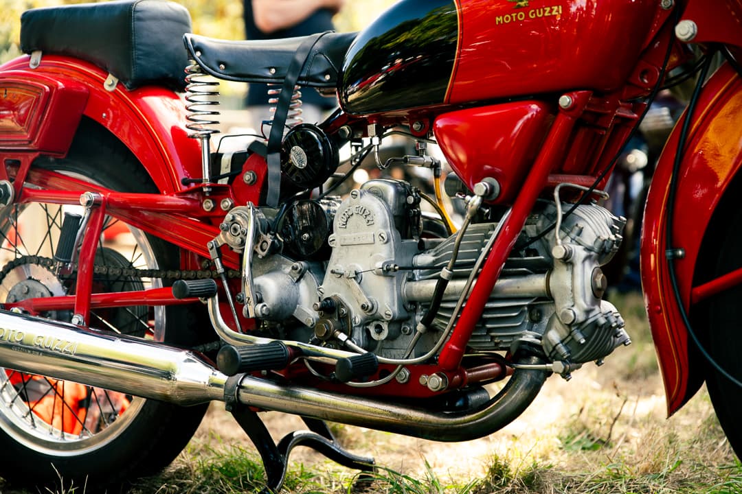 Engine and exhaust detail on a red Moto Guzzi motorcycle