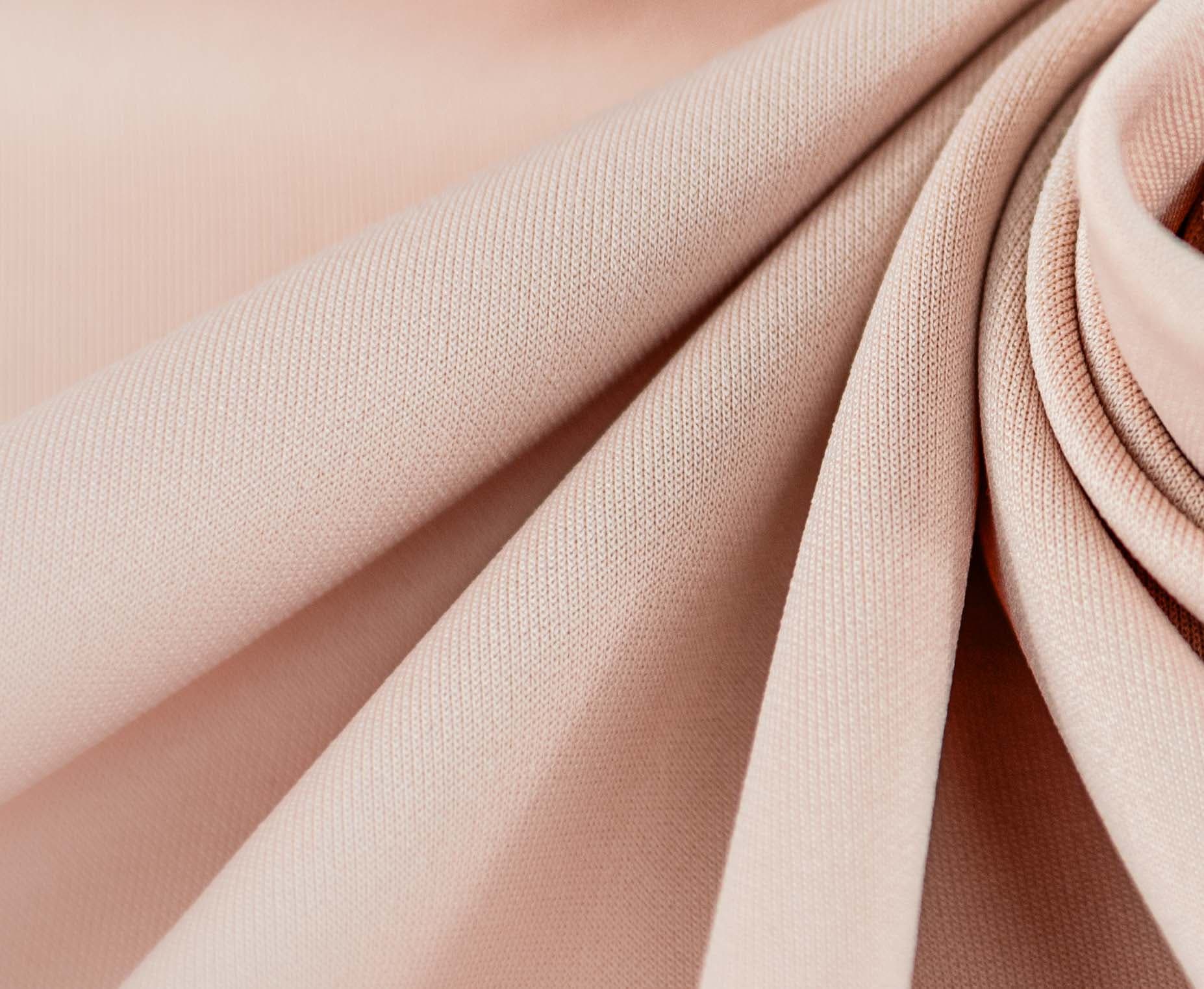 Close-up of beige cloth with floral twirls and folds