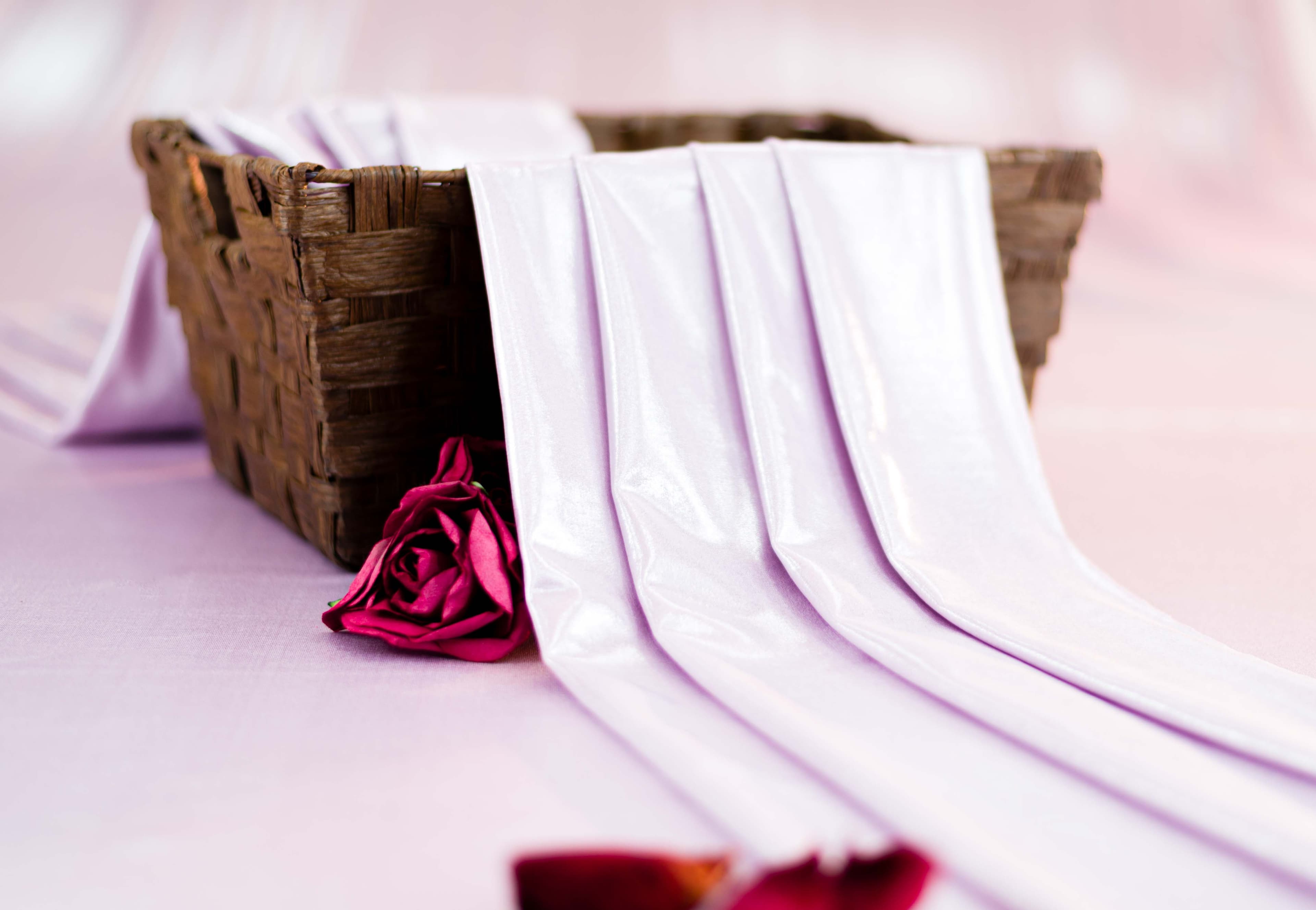 Flowing pink silky fabric spills from a basket