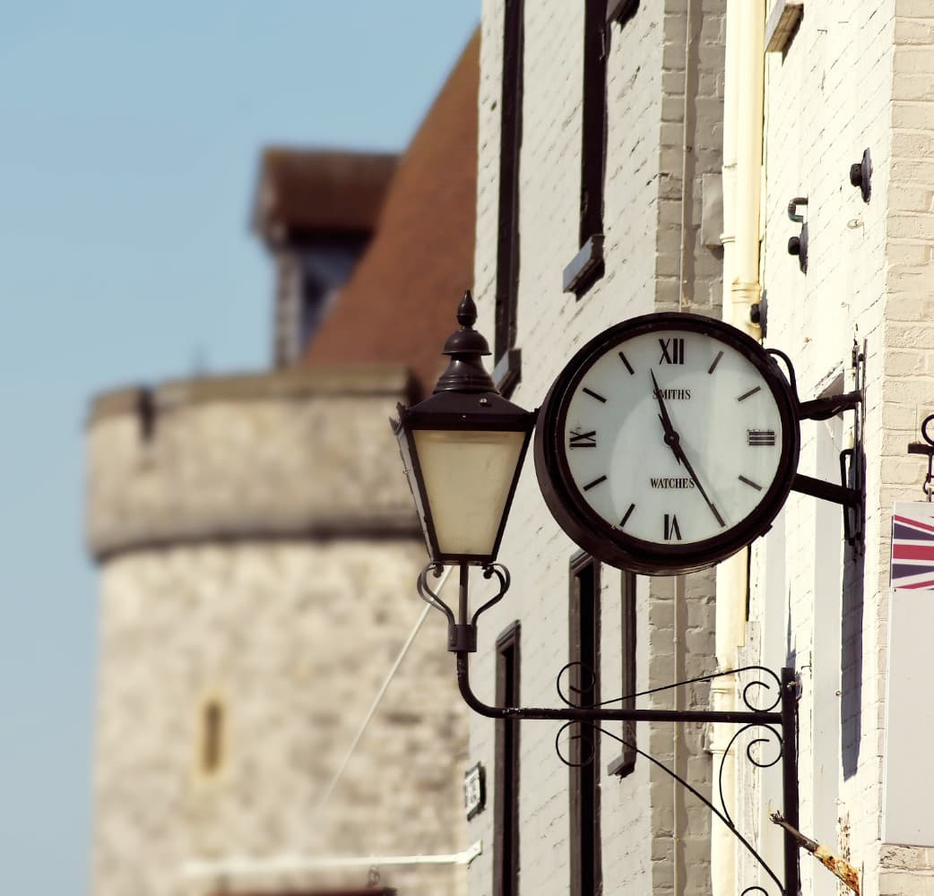 Foreground clock with blurred Buckingham Palace