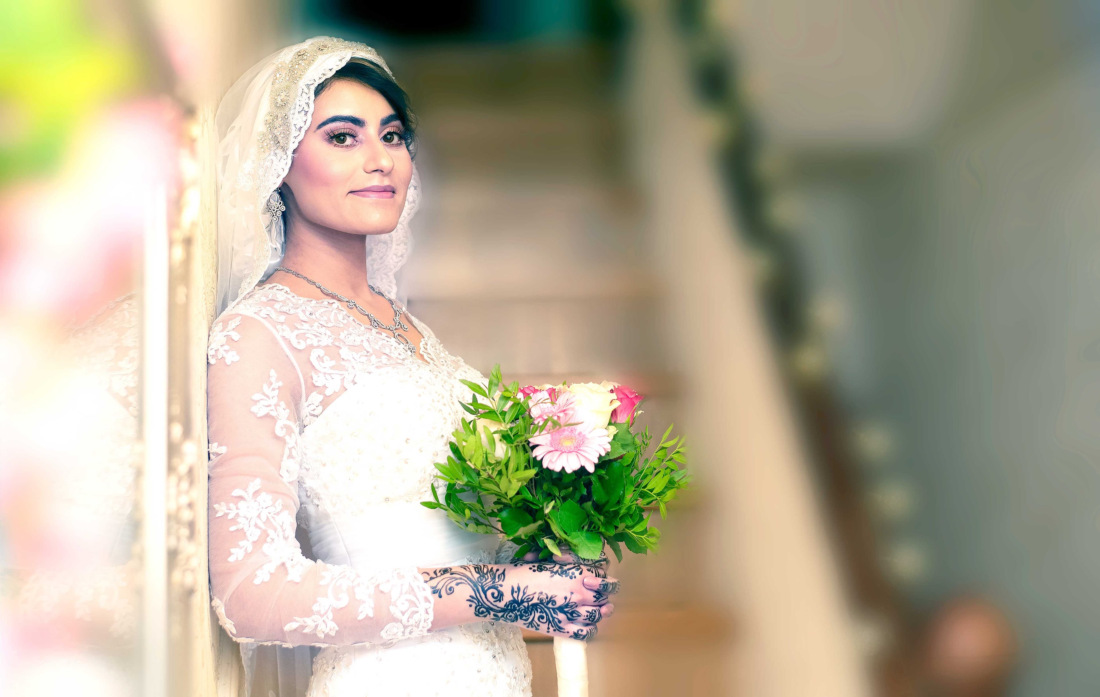 Bride with bouquet, gracefully reflected against a mirrored wall